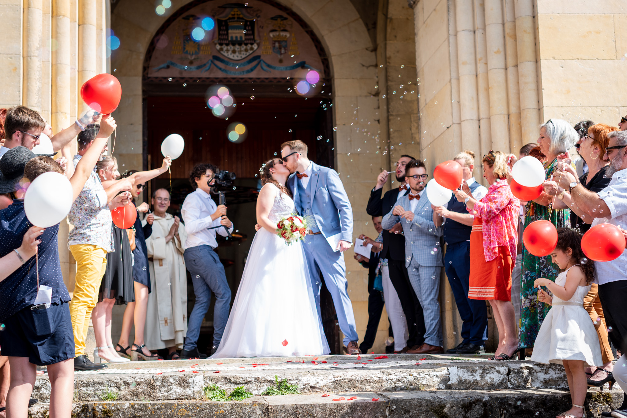 jeunes mariés s'embrassant sur le parvis d'une église, photographie de mariage