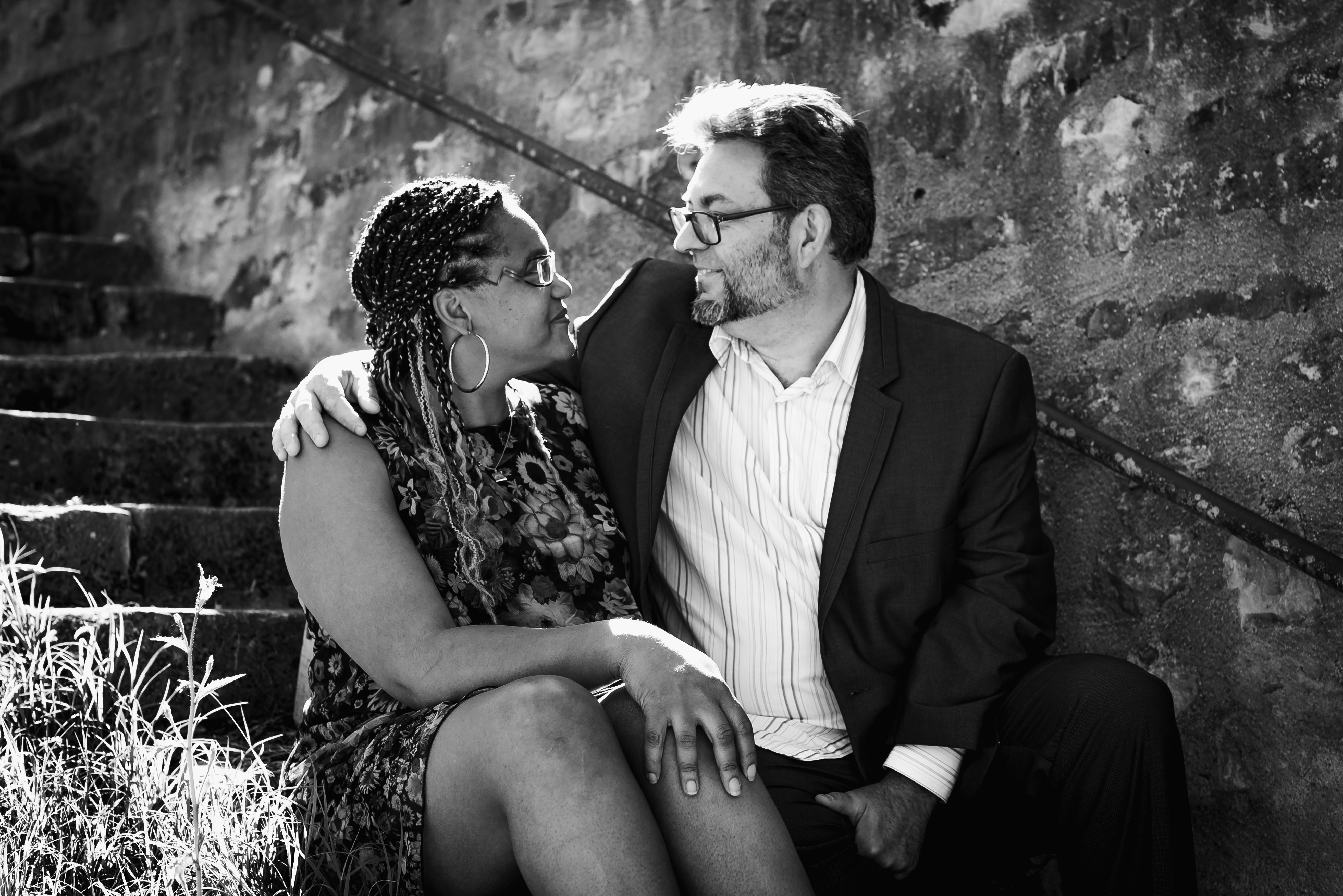un homme et une femme assis sur un escalier, se regardant avec émotion. Shooting artistique de couple